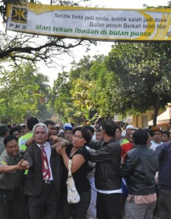 Police attempted to protect Christians of another church in Indonesia, but two of the church's pastors were beaten by the mob. The banner, carried by a radical reads "The Muslim community rejects the building of a church in Mustika Jaya."