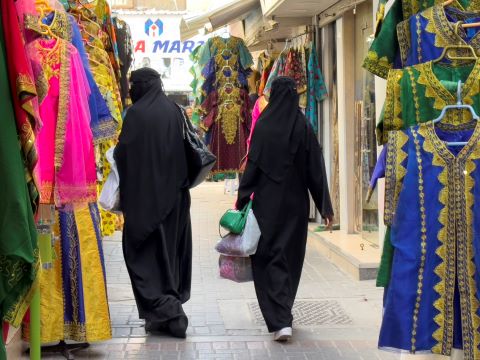 Women walk through a market in Bahrain