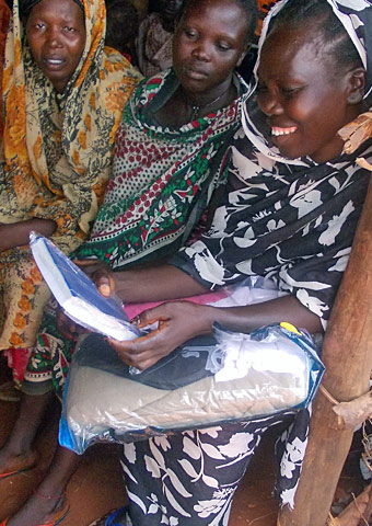 Women in Sudan look at a Bible received with their Action Pack.