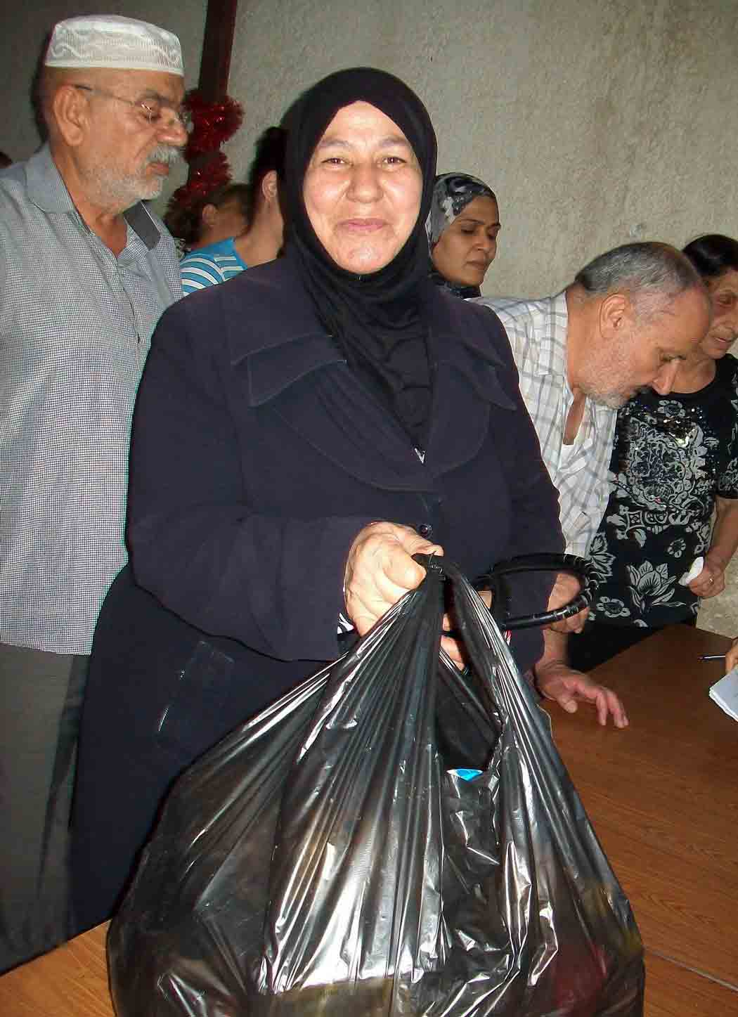 An aid recipient is overjoyed to receive a food package.