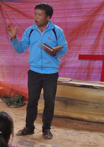 A preacher gives comfort to mourners during a believer's funeral service in Laos where believers are often prevented from holding funerals at all.