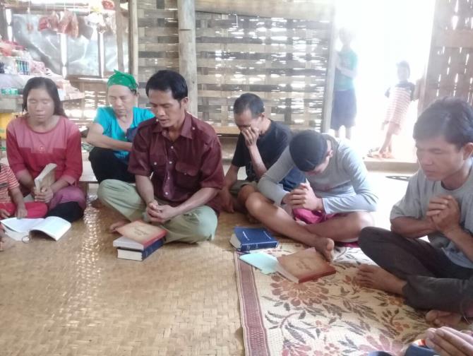 Believers in Laos pray during a Bible study.