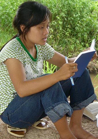 A young Christian teenager from Laos studies her Bible.