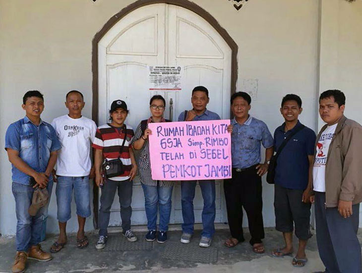 Members of one of the closed churches hold a sign that says: "Our Assemblies of God church has been sealed by the government." (Photo: World Watch Monitor)