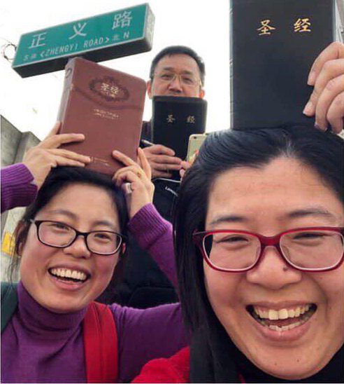 The spouses of arrested believers held Bibles over their heads while protesting outside the German embassy.