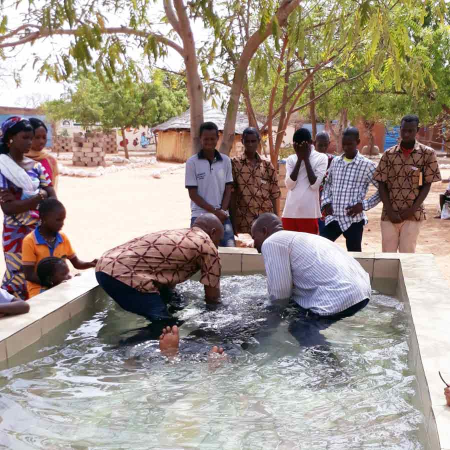 Evangelists in Burkina Faso baptist a new believer.