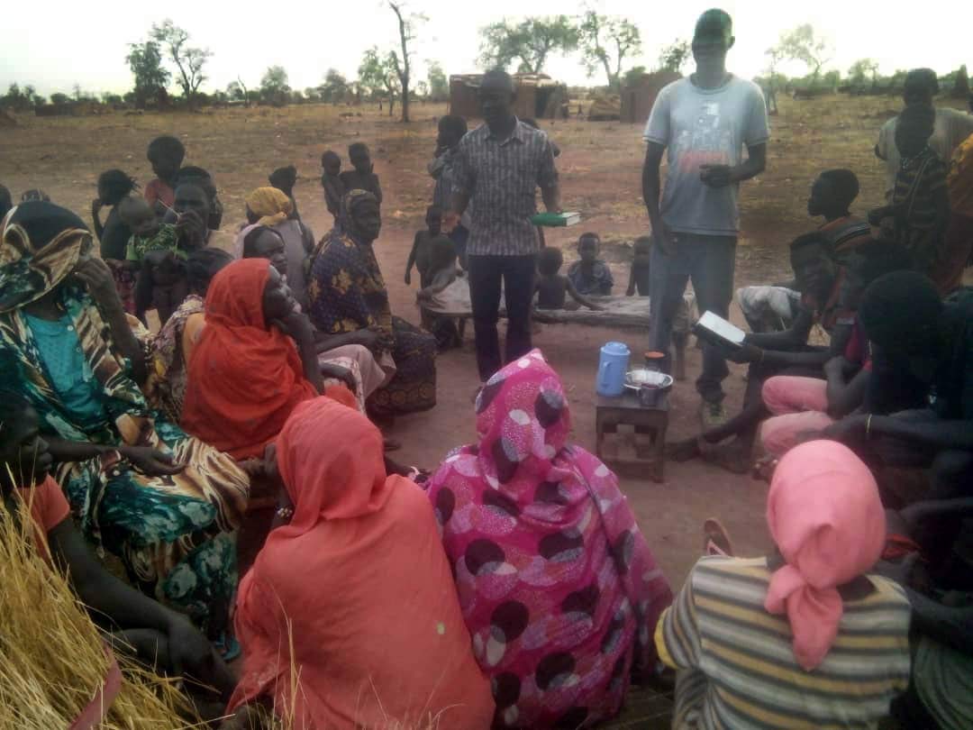 One of the team members preaches to a group of villagers.