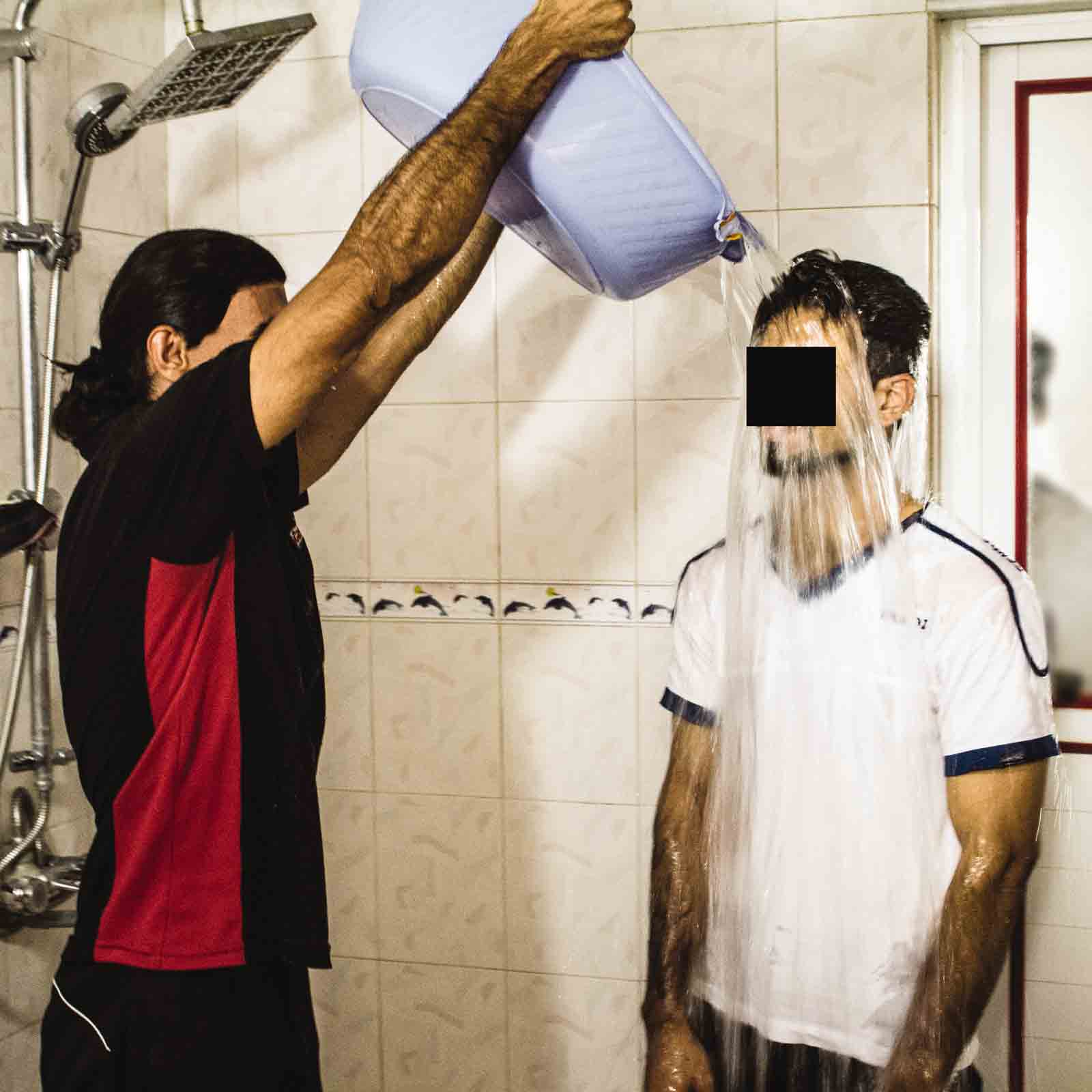 New believers must be secretly baptized, like this man was in a shower.