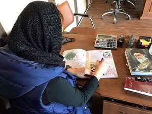 Tala's sister working on the crossword puzzle.
