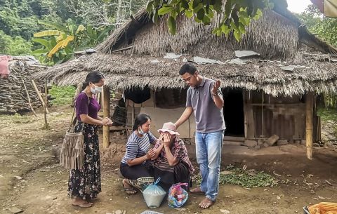 Christians in Laos minister to a woman in a nearby village.