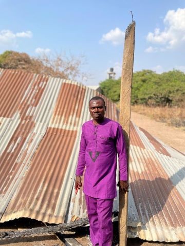 The pastor in front of the destroyed church building