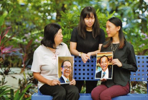 Susanna and her daughters hold photos of Raymond.