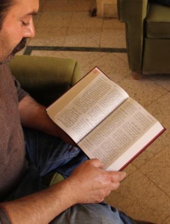 A new believer reads from a Bible he was given.