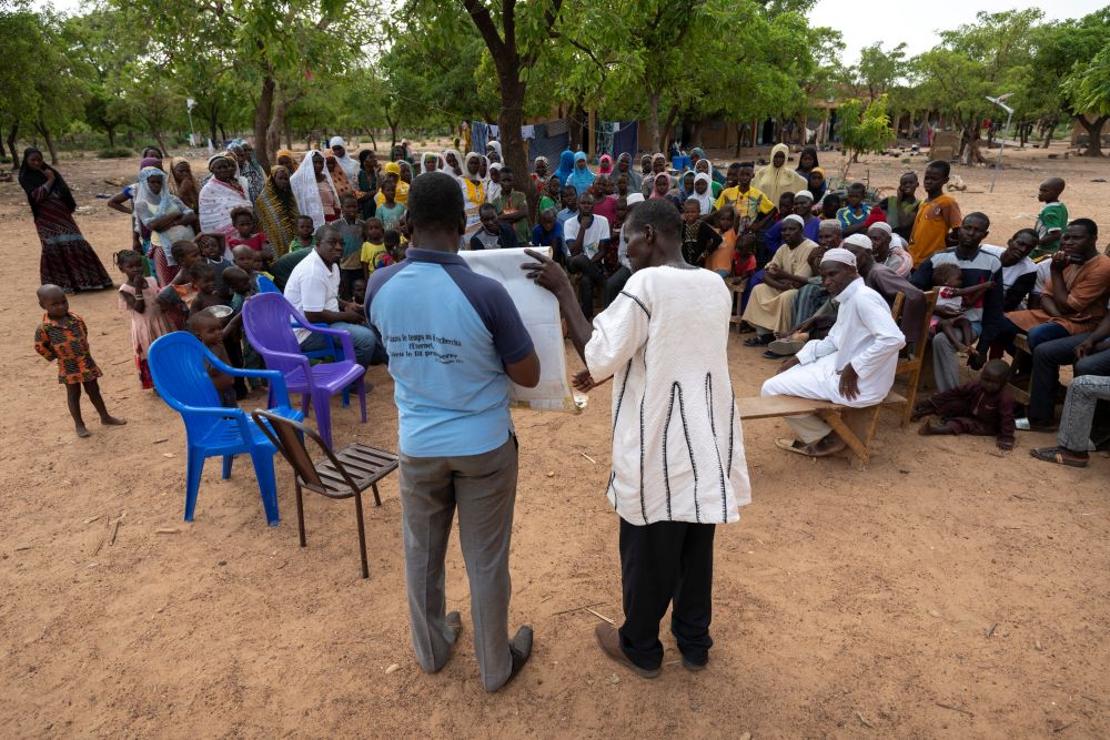 A Burkinabe evangelist explains the gospel to displaced individuals sheltering in a former school.