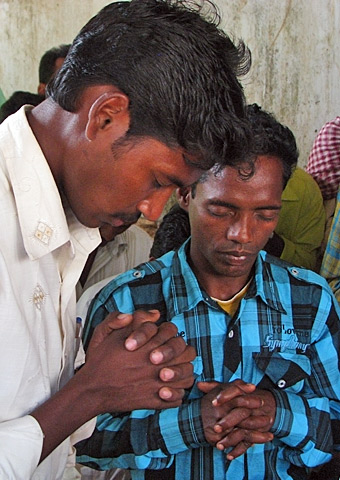 Men gather for prayer.