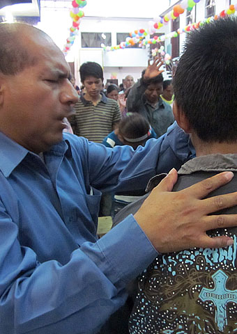 A pastor prays for members of his congregation in the Chiapas region of Mexico where Christians face hostility from rebel groups.