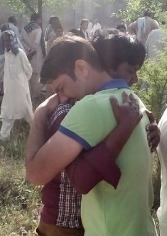 Christians comfort each other at a funeral for the victims of the Easter Sunday attack at a local park in Pakistan. (Photo credit: World Watch Monitor)