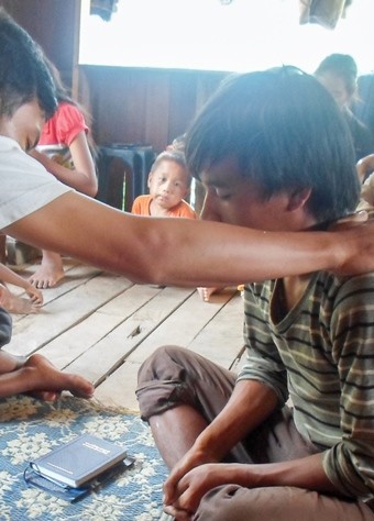 A Christian in Laos prays for a young boy.
