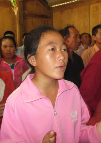 A woman worshiping at a church service in Laos.