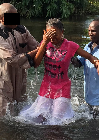 A woman from Sierra Leone is one of many new Christians being baptized.