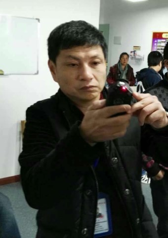 A Chinese official takes photos during a raid on a house church.