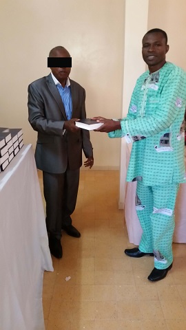 A pastor receives a Bible.
