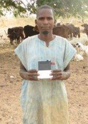 A Fulani man holds an MP3 player.