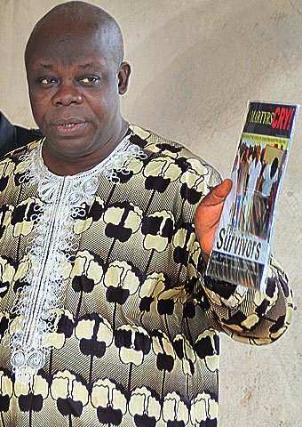 A man from Nigeria holds up copies of the VOM-Nigeria newsletter.