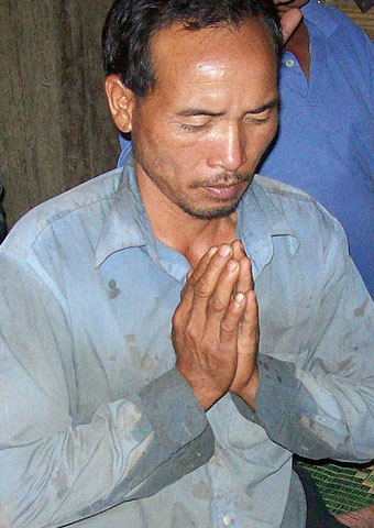 A man from Laos prays during a church service.