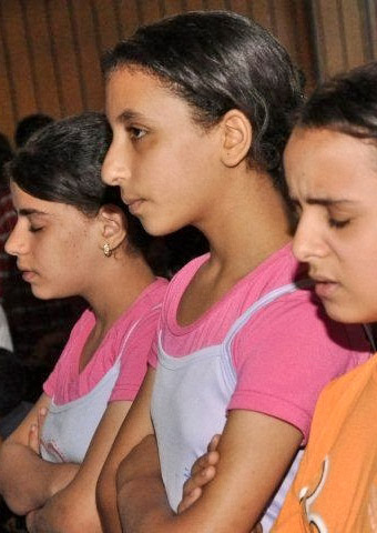 Young Christians pray during a worship service. Christian girls like are often at risk of being kidnapped because of their faith.